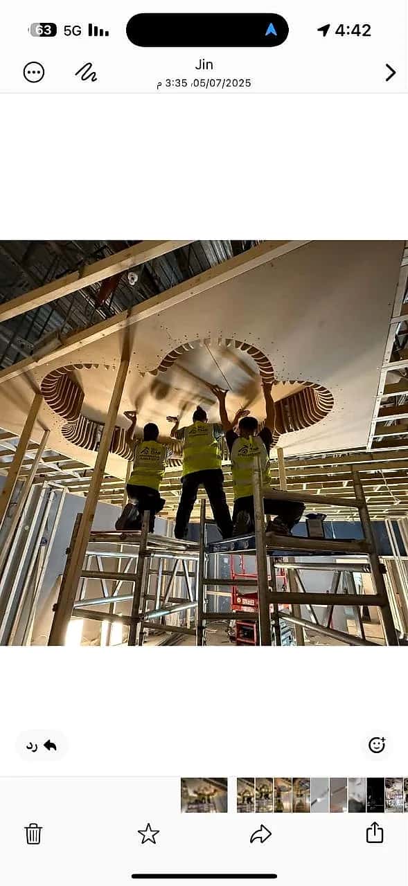 Three MO Team fitters on a scaffold tower fixing the timber ceiling feature of the Pop Mart store in Oxford