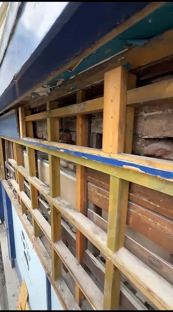The timber frame of an old shopfront exposed during strip-out, cladding removed