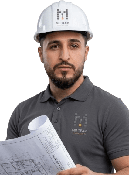 Mo, founder of MO Team Construction, in a MO Team hard hat holding a set of drawings