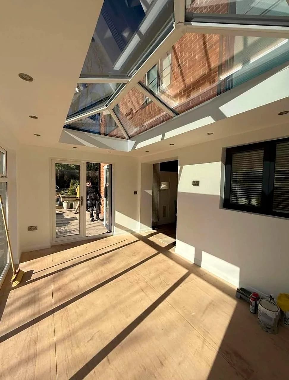 Inside a finished London rear extension, sunlight through the roof lantern onto a new oak floor